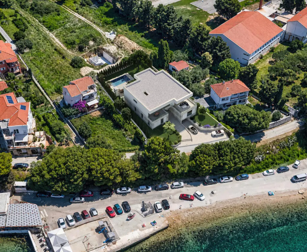 Lijepa moderna kuća uz obalu s pogledom na more i vrtom.